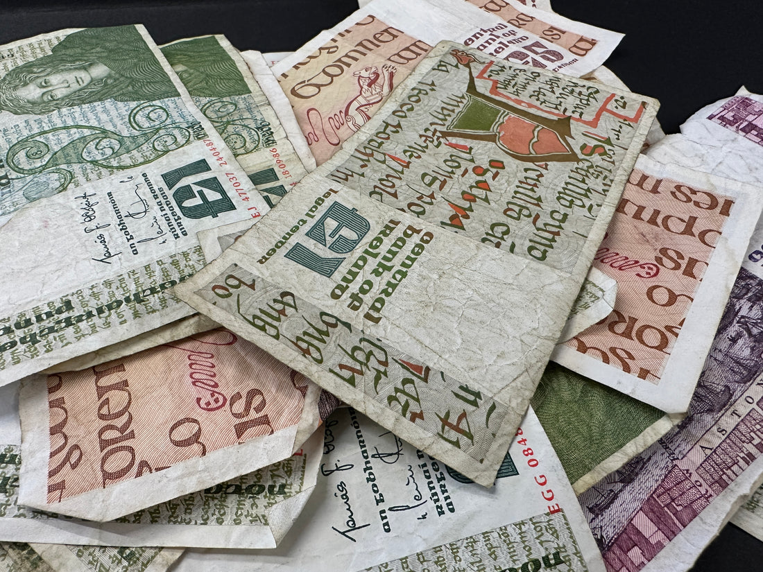 Pile of irish punt banknotes against a black background